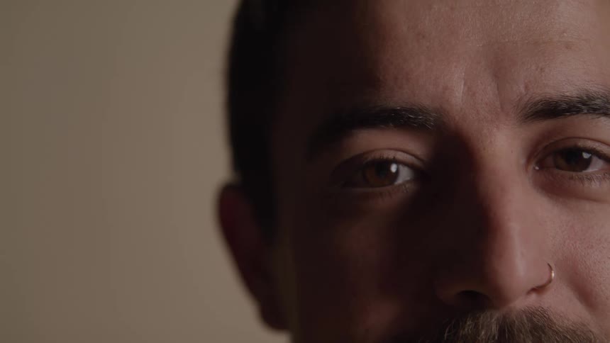 Male face in closeup highlights a serene gaze and soft features
