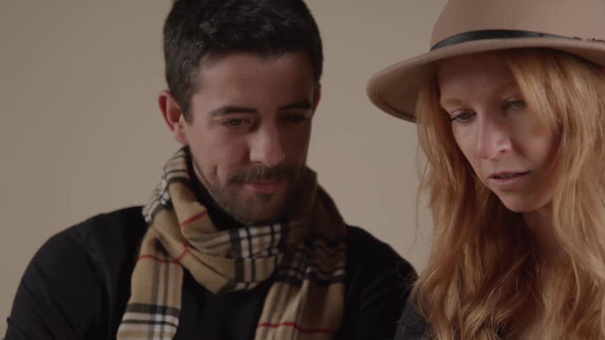 The man and woman smile while looking at images on the camera