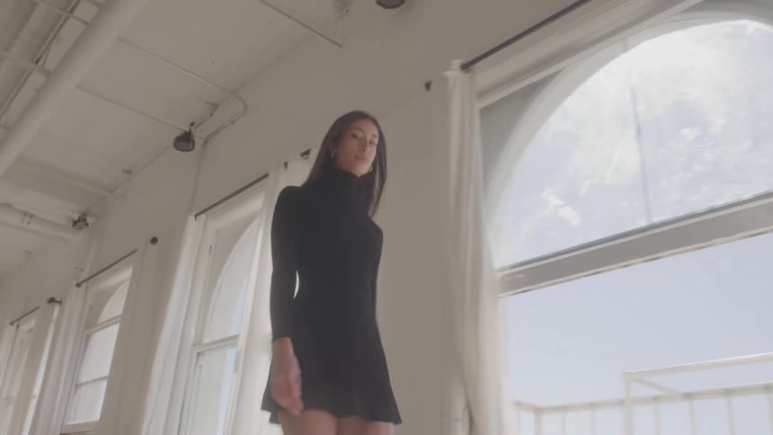 A young female model walking along a corridor indoors during daytime