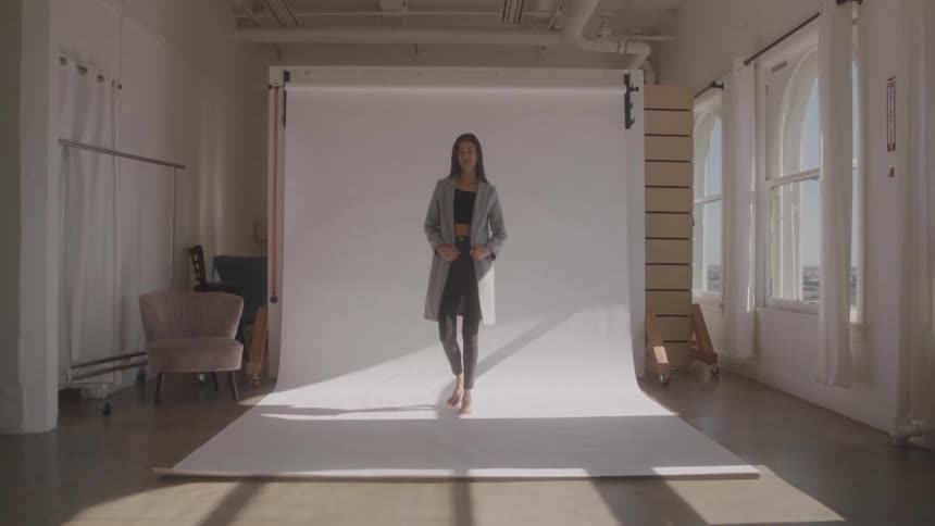 The model poses in front of the backdrop