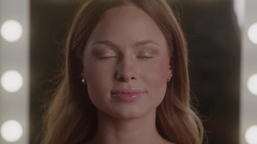 Woman with light brown hair facing the camera in a setting lit by circular lights