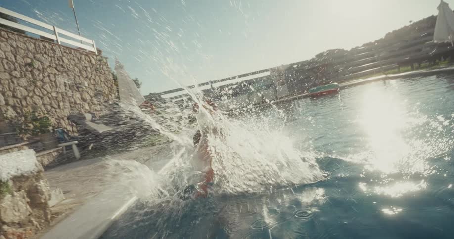 Boy jumps into the pool on a sunny day