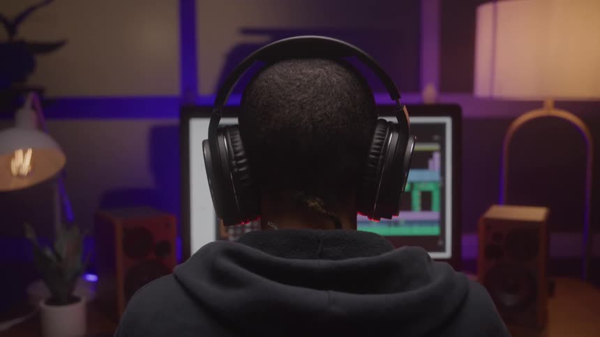 Close up of a young black woman working with a desktop computer in a music studio
