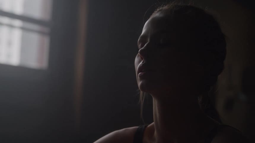 Close up of a young woman sitting in a room after a fitness session during daytime