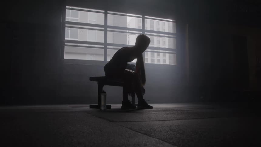 A woman ties her shoelaces in the gym before a workout