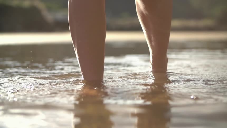 Persons feet traveling in shallow water