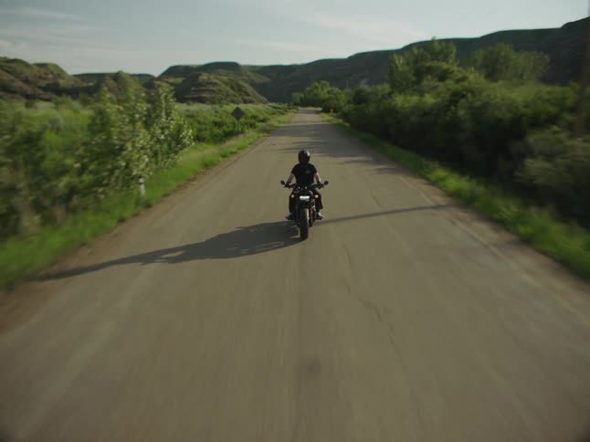 The man rides over the blue bridge
