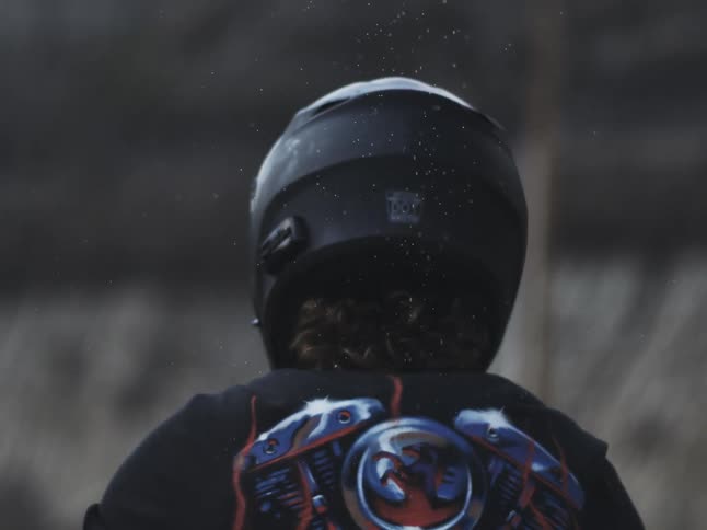 The person is wearing a black motorcycle helmet outside