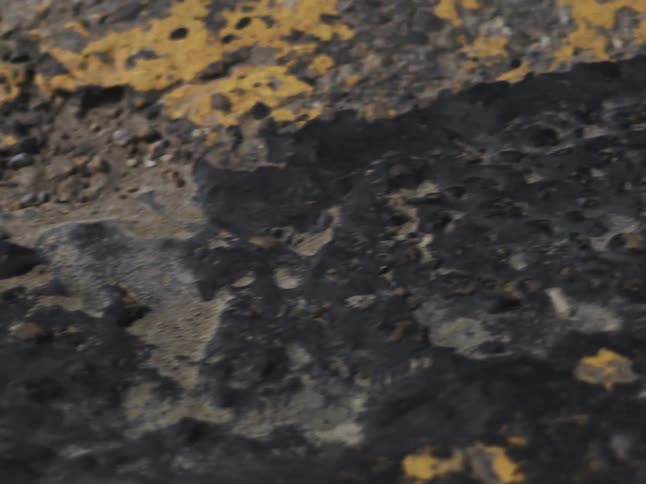 The road has cracks and holes in it
