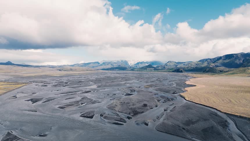 Vast landscape with braided channels over arid terrain under a blue sky