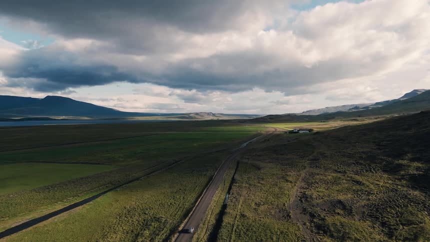 The car drives down the long small road on the field