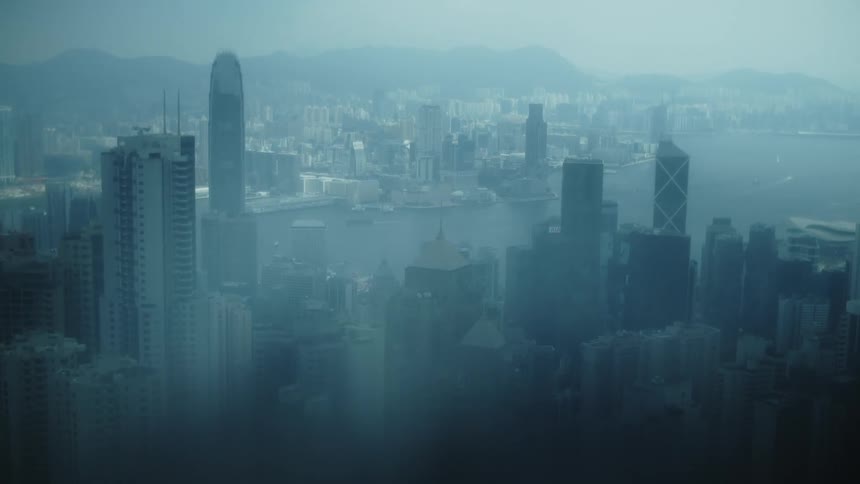Dense fog obscures a city located near the mountains and the ocean