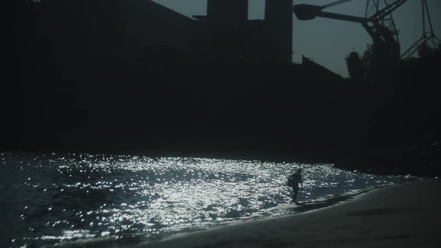 Woman collects water from the sea on the beach