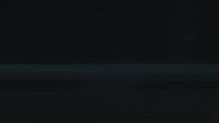 A dark background shows blurred close up of a city street structures