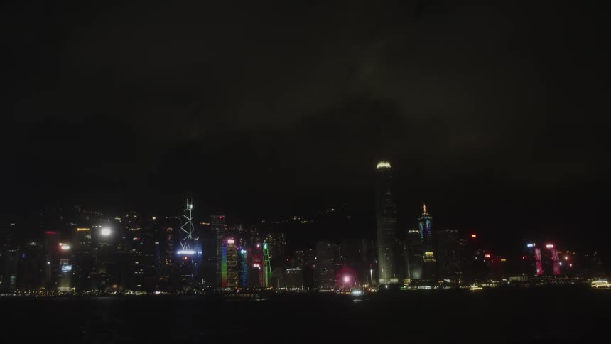 City skyline with skyscrapers reflecting in harbor water at night