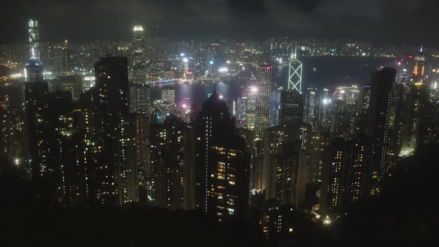 The glittering densely packed skyline of hong kong at night overlooking victoria harbour