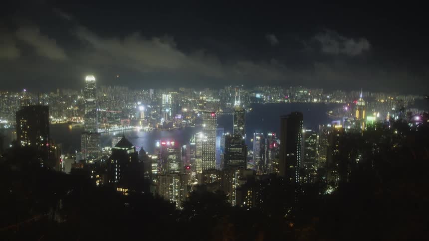 The dazzling night skyline of a bustling city with countless illuminated skyscrapers reflecting across a body of water