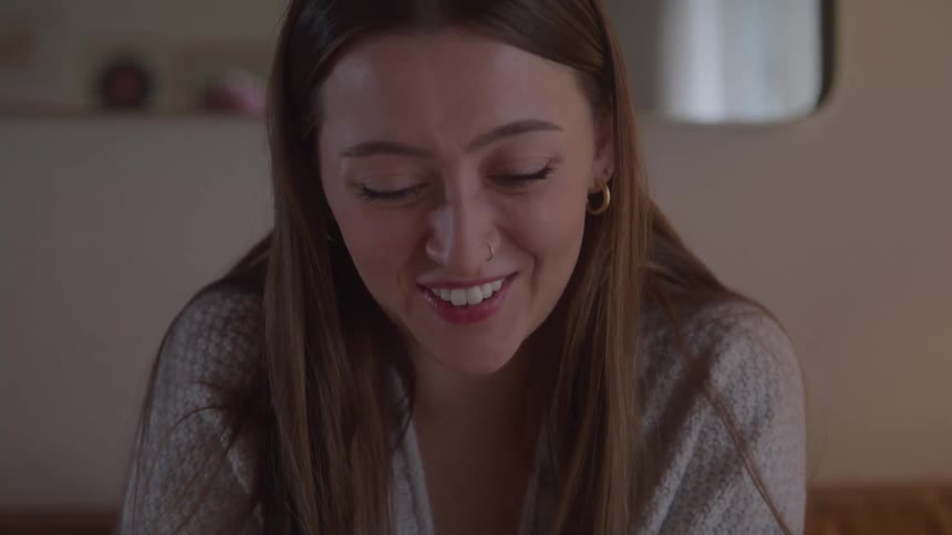 Woman smiles and gestures excitedly during a conversation indoors