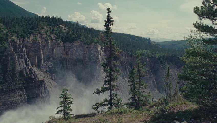Mist from waterfall rolls through the mountains