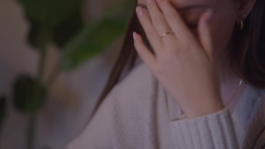 Woman rests her head on her hand with a worried expression