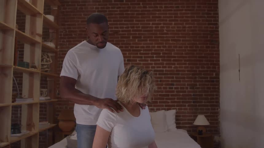 The man is massaging a womans shoulders