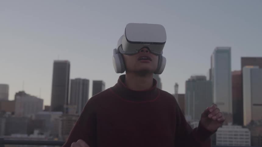 The woman is in awe while using a virtual reality headset on the balcony