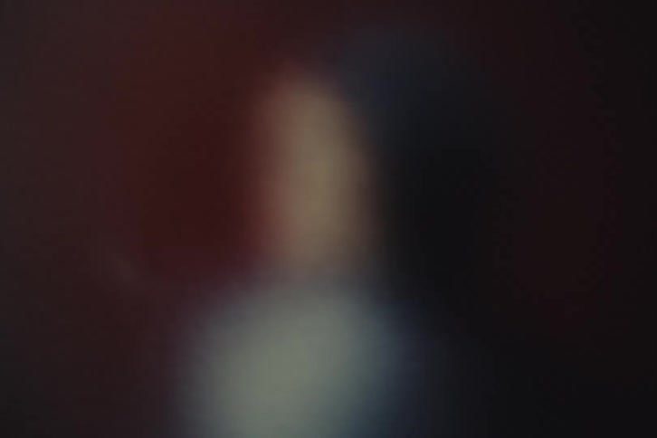 Close up of a young woman moving behind a frosted glass