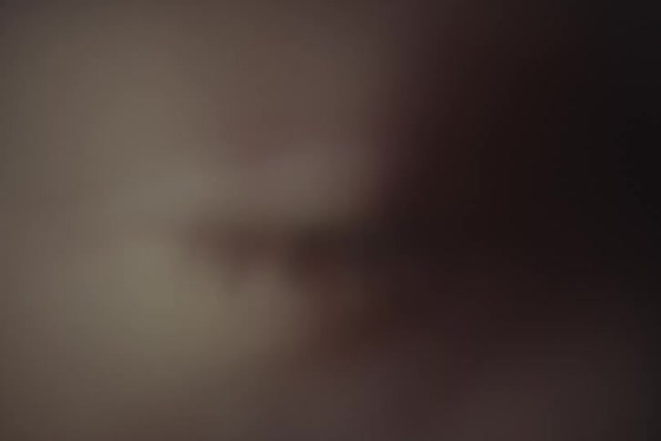 A closeup shows a womans face with her eye blinking
