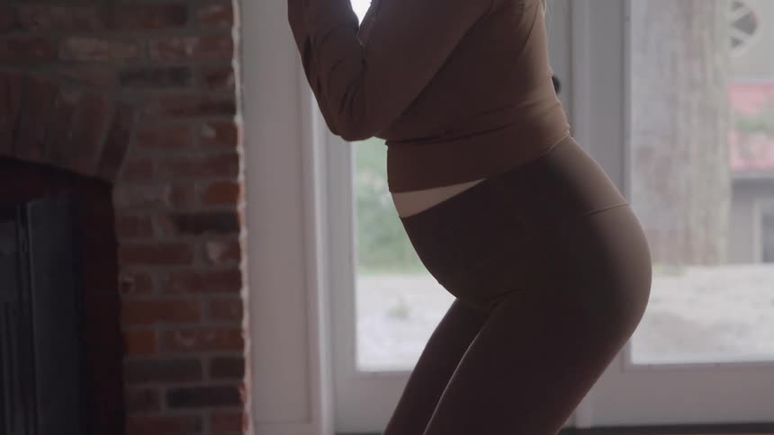 Pregnant woman exercising with dumbbells at home