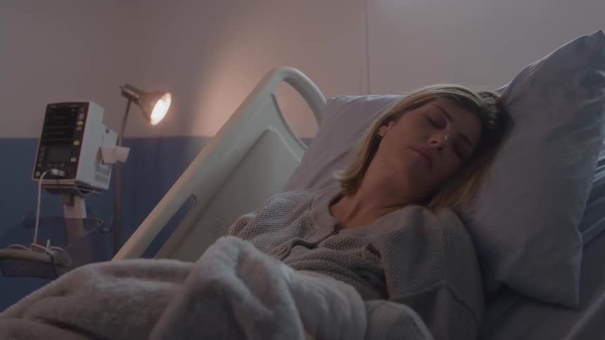 Woman rests in silence lying on a hospital bed