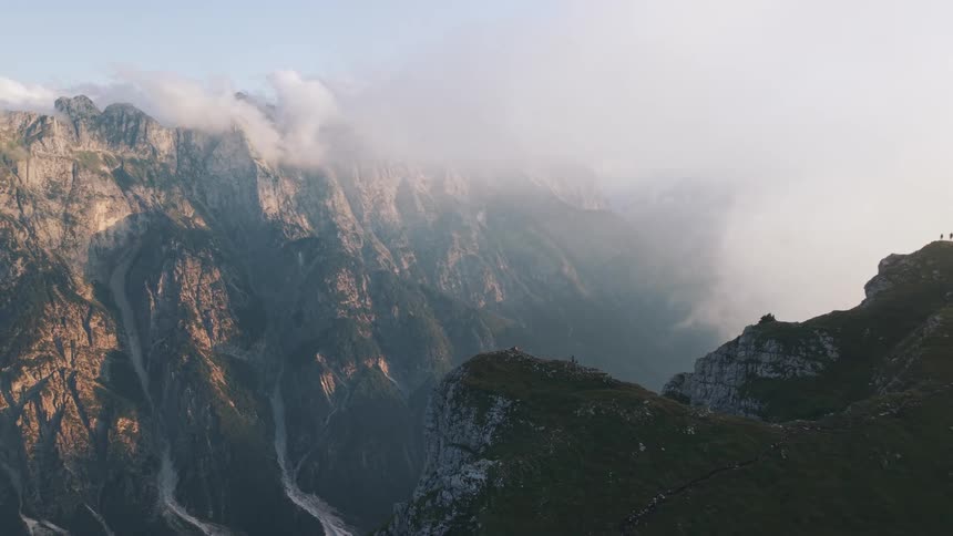 Rocky peaks shrouded in mist rise under the soft light of dawn