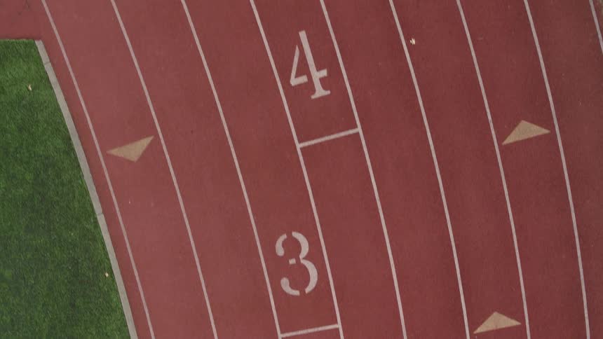 Low traverse over an empty running track with various lane markers