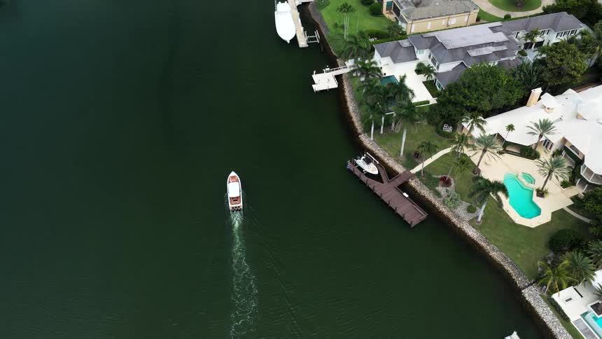The boat travels past the homes on the shore