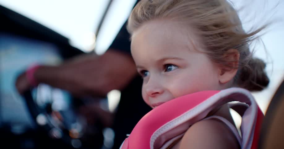 Wind blows the girls hair as she rides on the boat