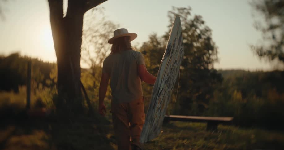 Person carries a large canvas outdoors during sunset