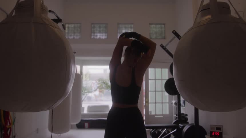 Woman stretches her body while exercising in a gym