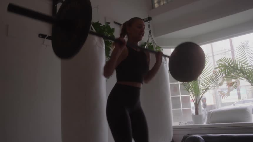 Woman trains weightlifting on the free bar