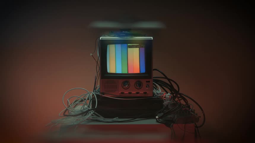 Retro television displaying color bars surrounded by tangled cables