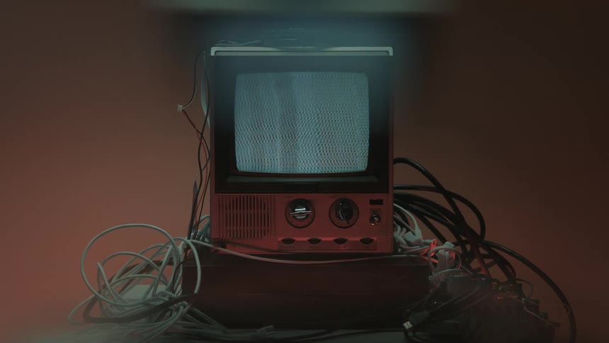 Close up of a person turning on a connected electronic display device on a table in a red lit room