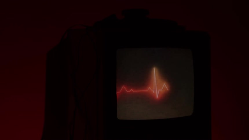 The television in the dark room displays a heart line