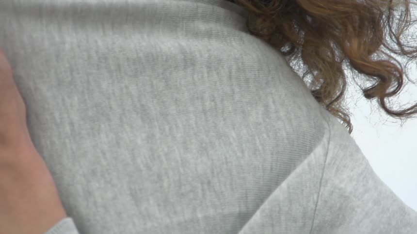 A woman smiling as she covers up
