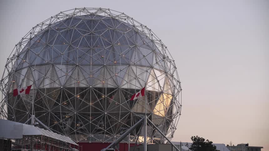 Glazed geodesic structure with canadian flags around it