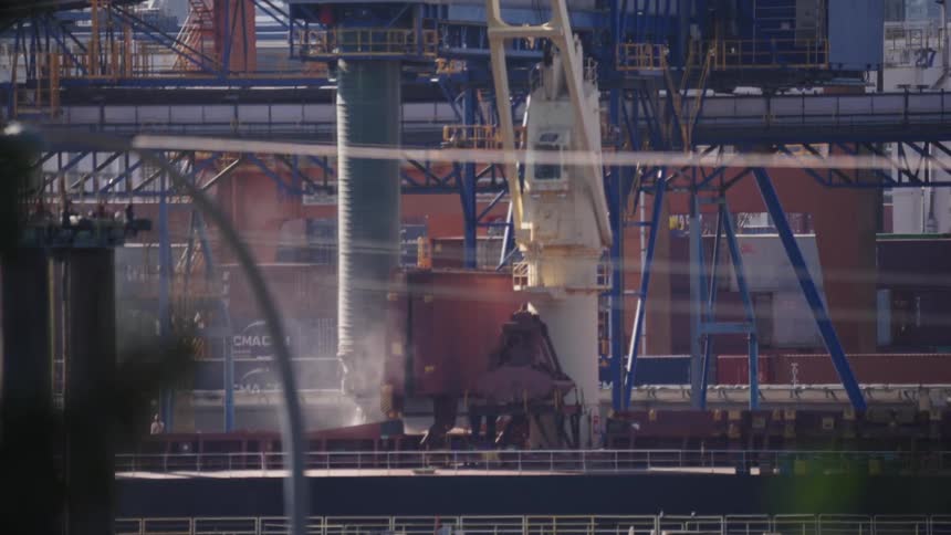 The machine with a long tube filled a shipping container