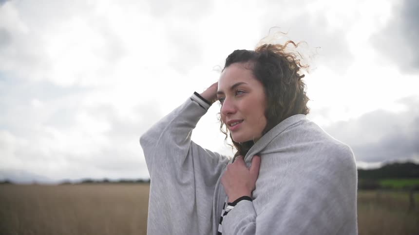 Woman standing under a cloudy sky