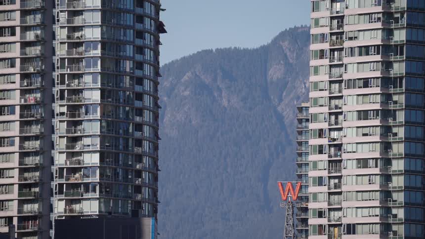 The sign is spinning in front of the buildings