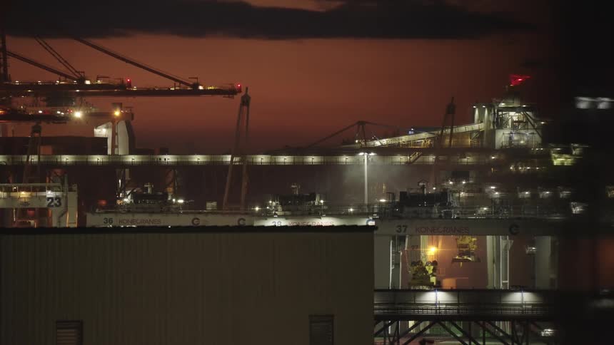 Cranes and port structures illuminated at dusk