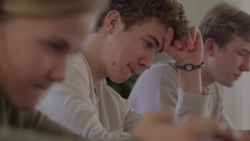 Three teenager sit reading together