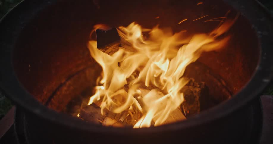 The logs burn in the fire pit