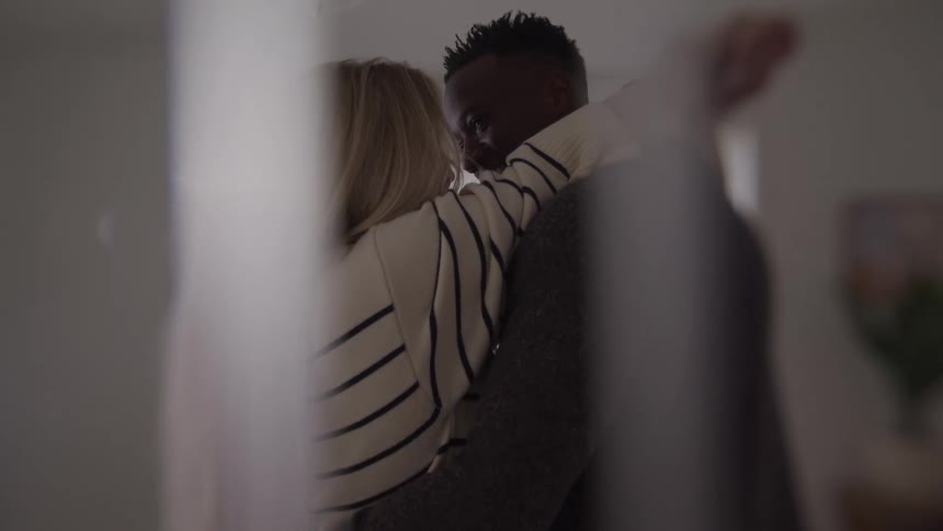 Couple embraces lovingly while sharing a close gaze