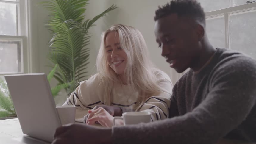 Couple smiling while looking at a laptop screen